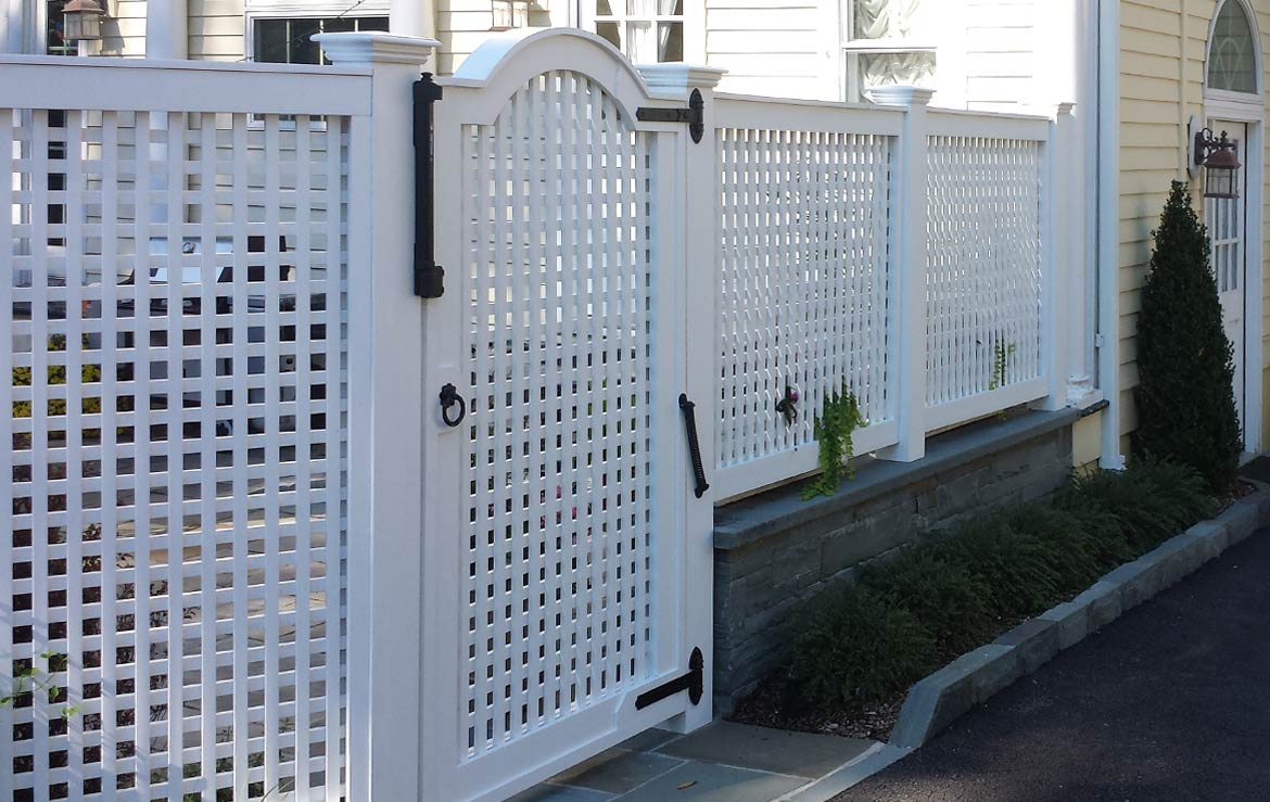 Custom lattice fence and gate. Bluestone curbing and wall.